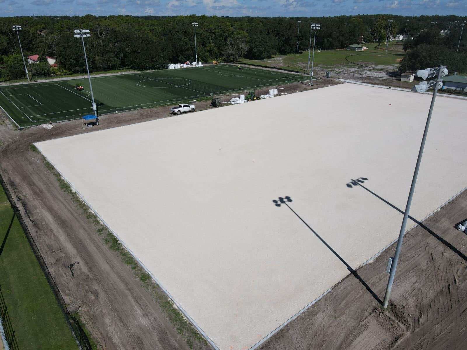 Compacted, laser-graded base next to a finished turf field