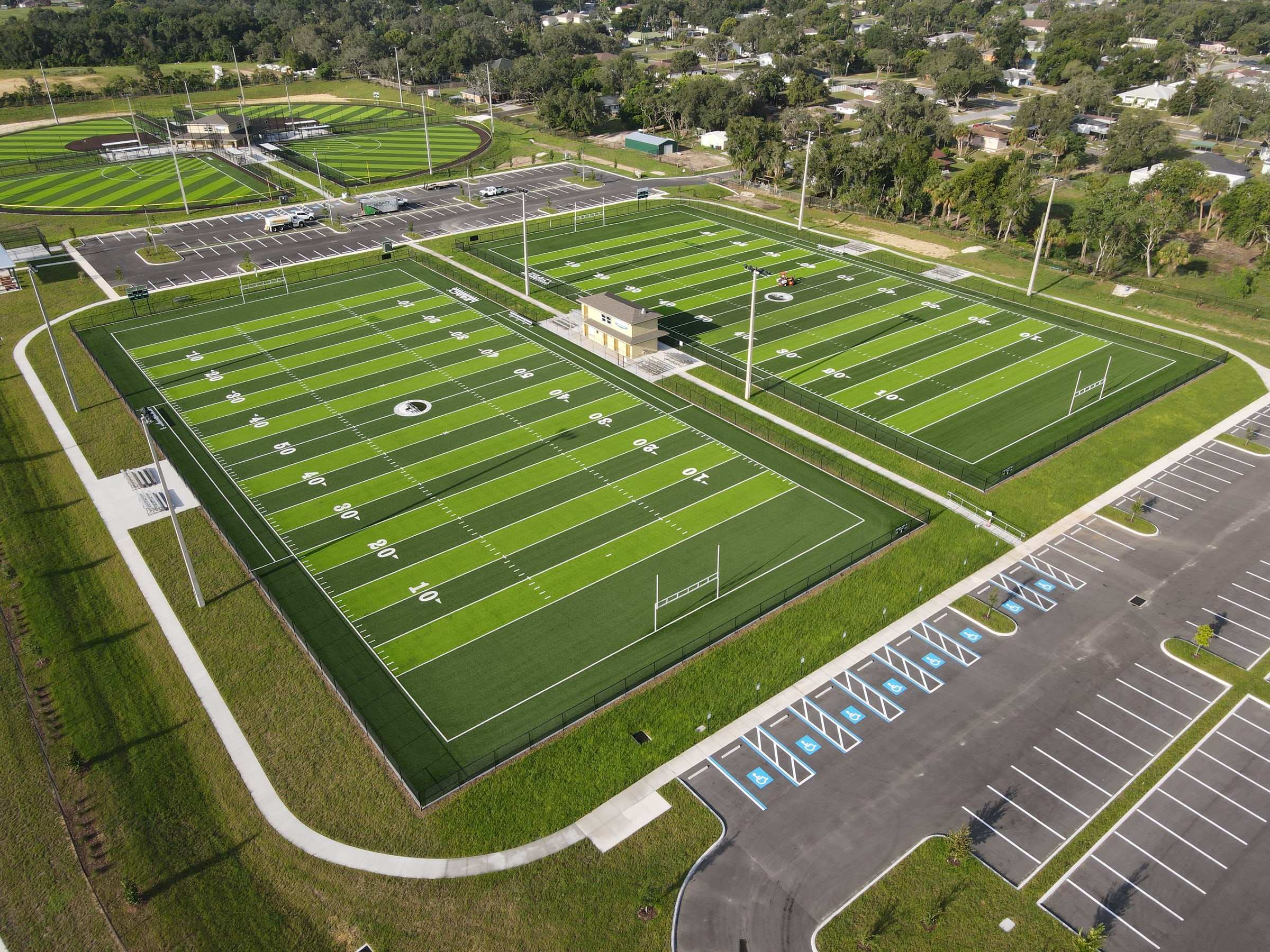 Aerial view of two turf football fields with a press box
