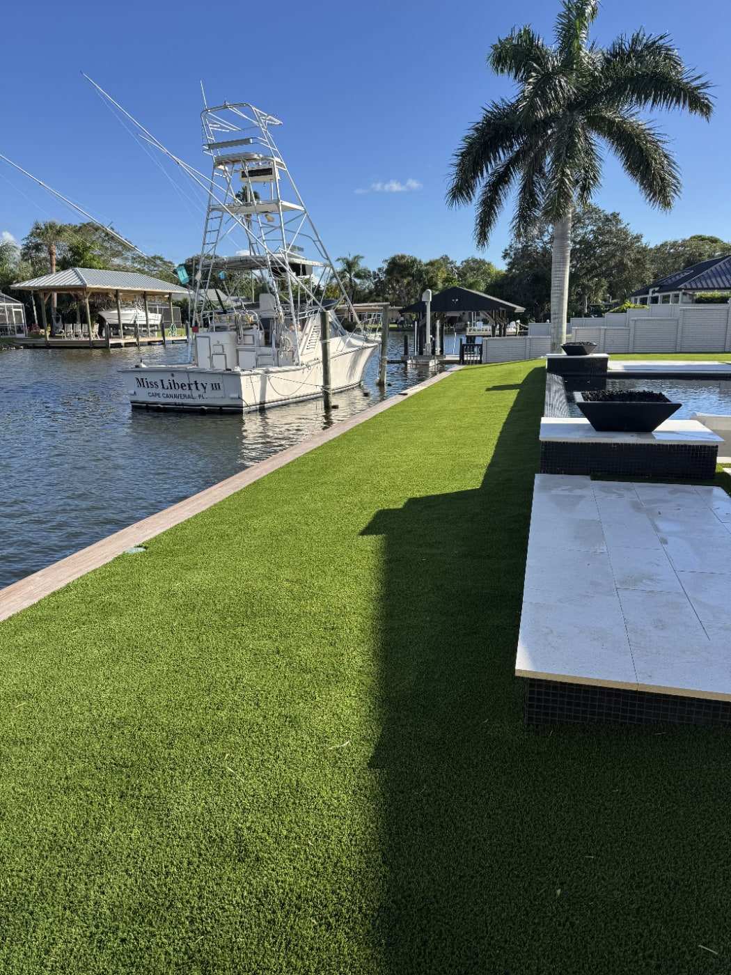 Waterfront turf lawn beside a canal and pool