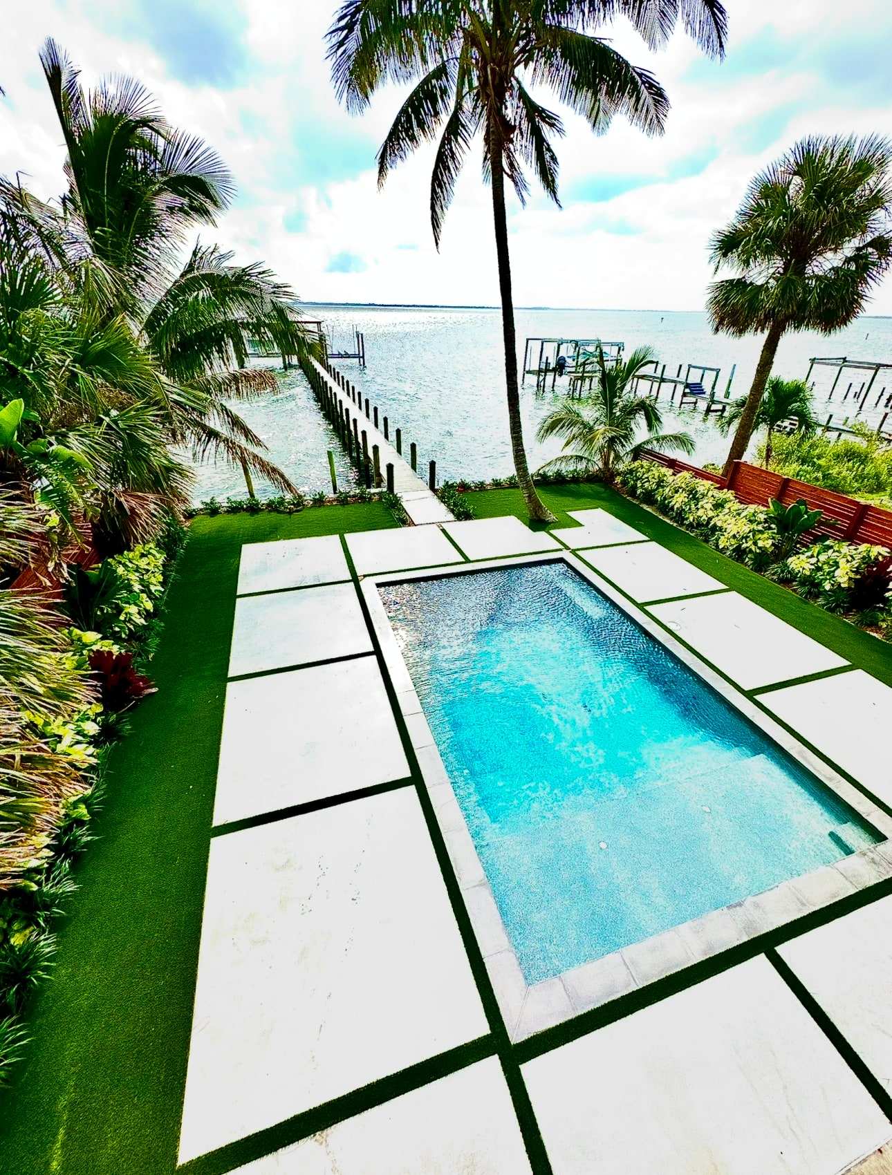 Waterfront pool yard with turf between pavers
