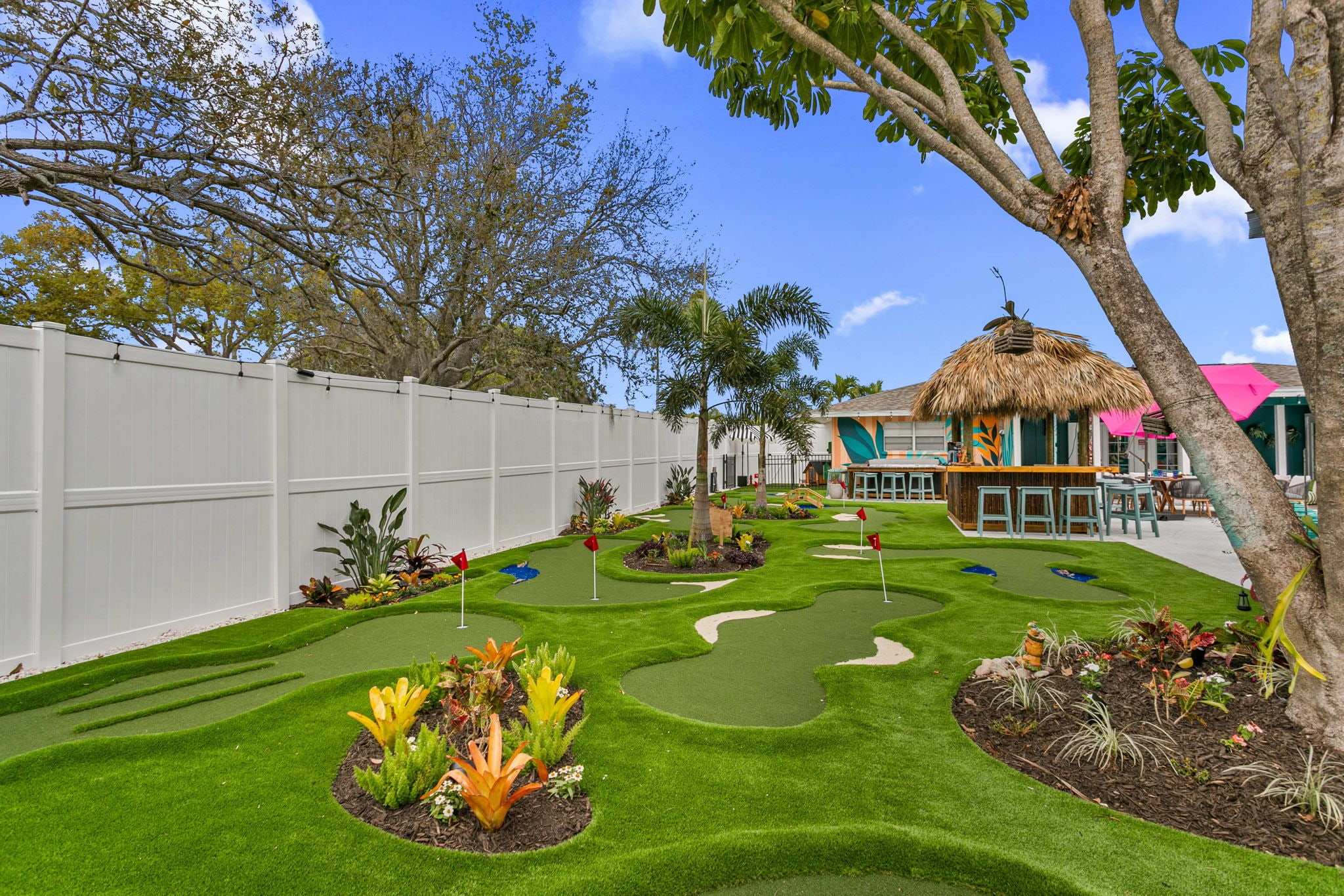 Multi-hole turf putting course with bunkers and a tiki bar
