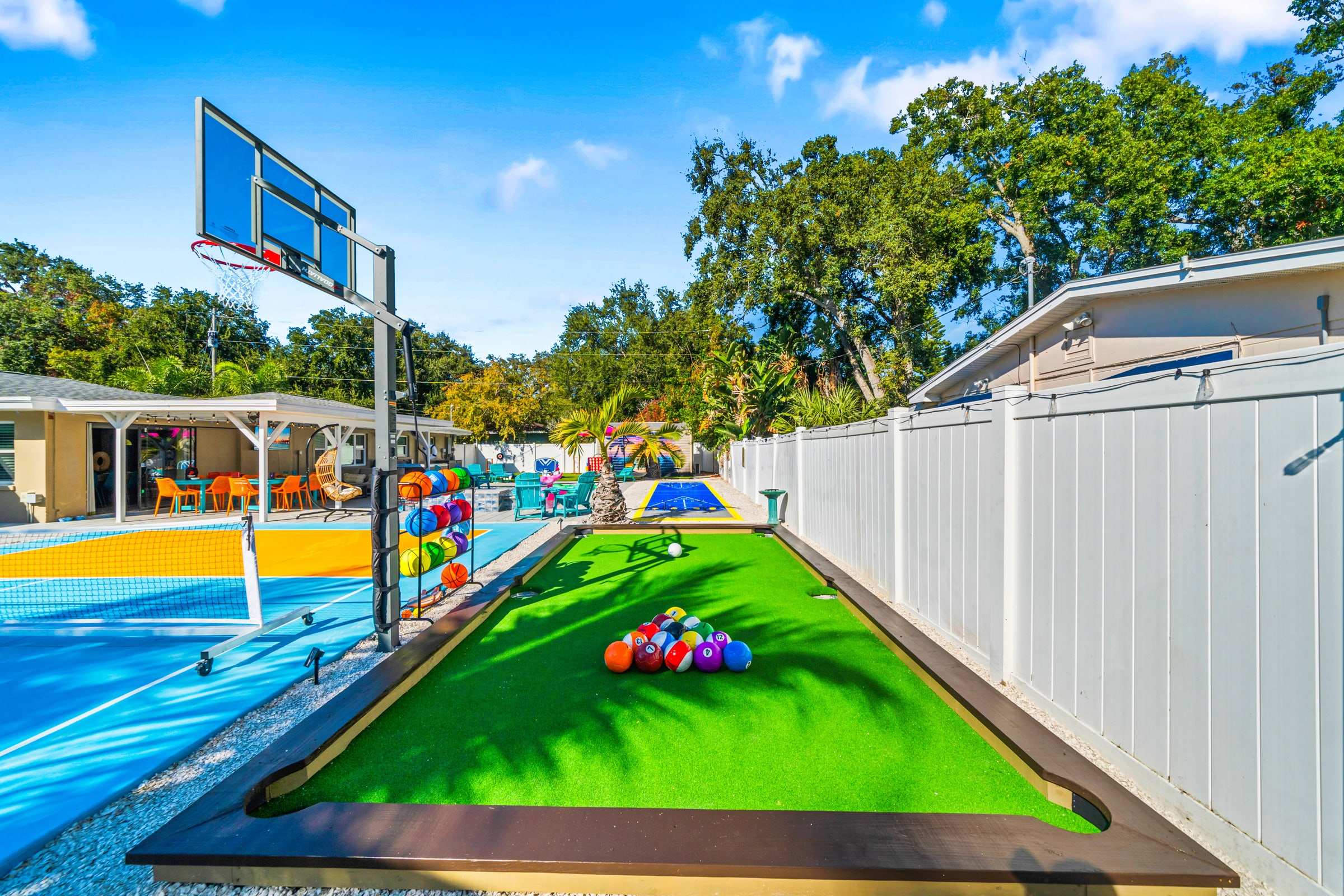Backyard turf billiards game beside a basketball court