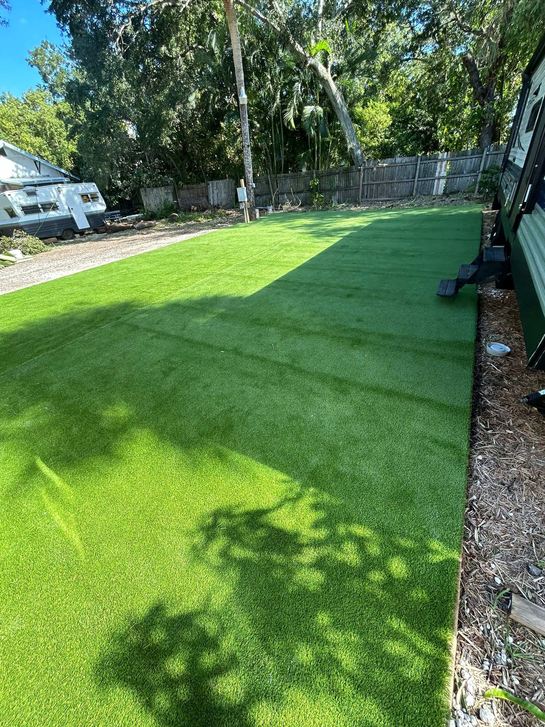 Turf putting green in front of a brick house