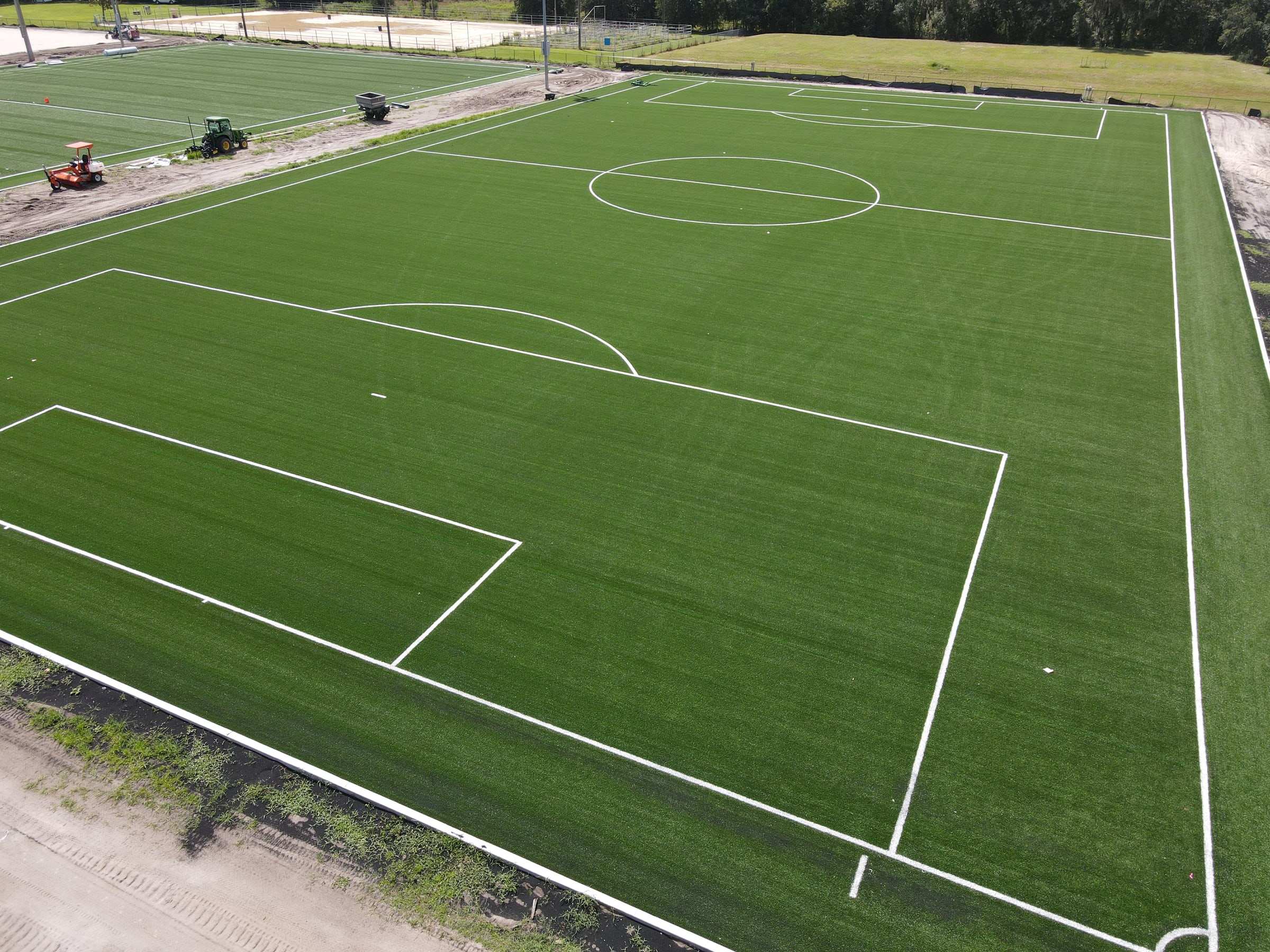 Newly installed turf soccer field showing the penalty box and center circle