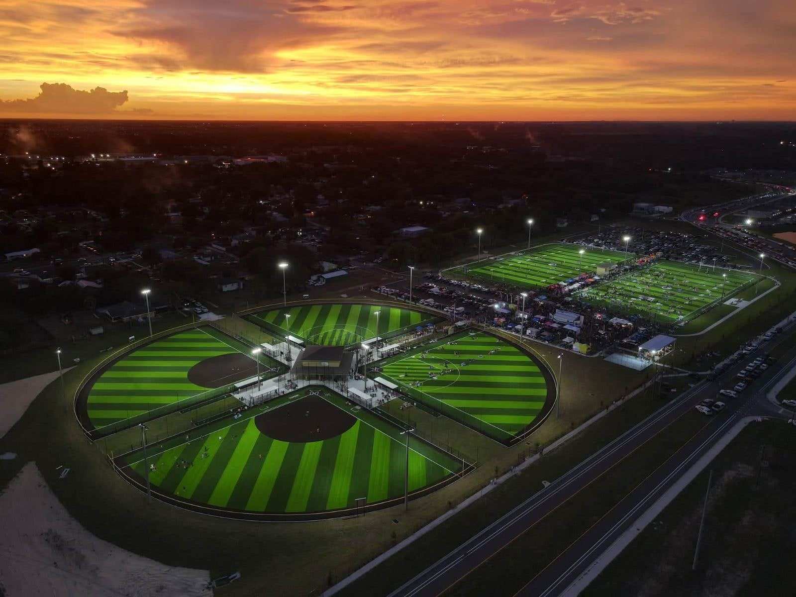 Lit sports complex with Turf Factory fields at sunset